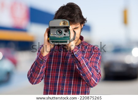 cool indian man taking a picture with a photo camera