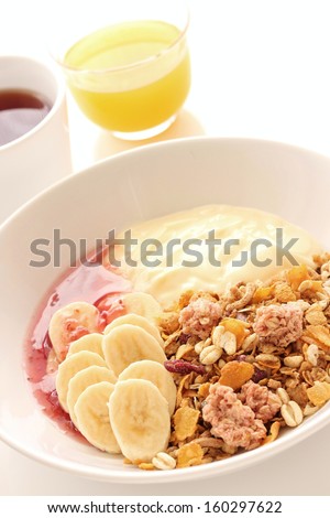 Granola, banana, yogurt and rapsberry jam for healthy breakfast