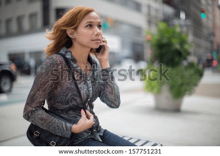 Latin Hispanic Asian woman talking on cellphone iphone smartphone on city street