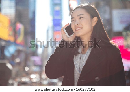 Asian woman in New York City Times Square calling talking on phone callephohe