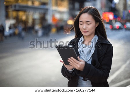 Asian woman in New York City Times Square using tablet pc