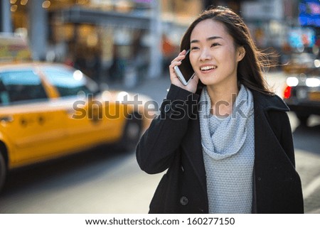 Asian woman in New York City Times Square calling talking on phone callephohe