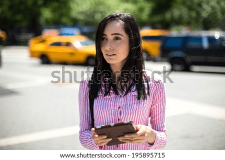 Young latina hispanic woman in New York City walking using tablet pc computer