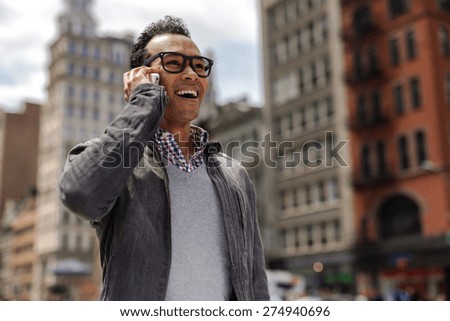 Young black African Asian man in city talking on cell phone