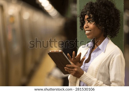 Young African American black woman using tablet pc in subway station