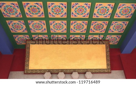 Traditional chinese flowery ceiling decoration,along with golden panel framed by geometrical motifs, in the Huating-Pavilion of Splendor buddhist temple, Kunming, Yunnan, China.