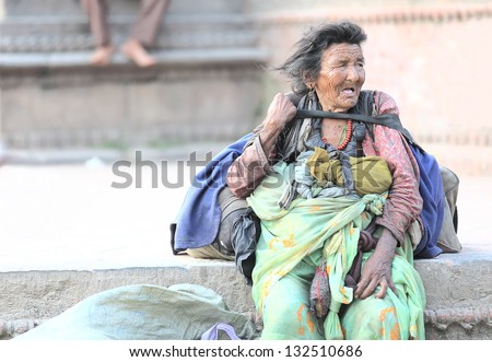 KATHMANDU, NEPAL - OCT 4: A homeless woman sits beside the road to rest after begging to the people passing by on October 4, 2012 in Durbar Square-Kathmandu-Nepal
