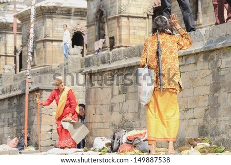 DEOPATAN, KATHMANDU, NEPAL - OCTOBER 5: Thin sadhu greets faithfuls expecting for him to attend them on the ghats of Bagmati river on October 5, 2012 in Pashupatinath temple-Deopatan-Kathmandu-Nepal.
