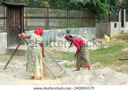 CHITWAN, NEPAL - OCTOBER 14: Local women work in maintenance tasks of the Gharial Conservation Program facilities on October 14, 2012. Chitwan Nnal.Park and distr.-Narayani zone-Nepal.