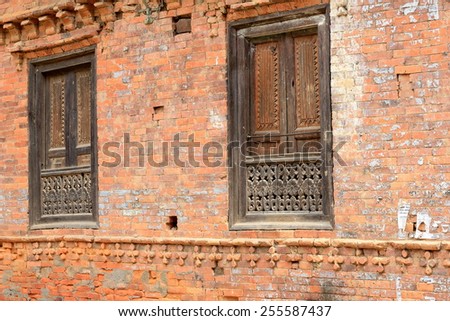 Traditional newar style red brick old house with carved wooden windowsills and roof struts-clothes hanging in the old city area. Dhulikhel-Kavrepalanchok distr.-Bagmati zone-Nepal.