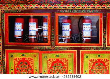 DREPUNG, TIBET, CHINA - OCTOBER 19: The monks keep fire extinguishers inside a red and gold commode on October 19, 2012. Drepung-Rice Heap monast.of Gelugpa-Yellow Hat order. Foot of mt.Ghephel-Tibet.