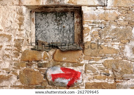 Closed small wooden window and red direction sign on the stone wall of the 1416 AD.founded Drepung monastery of the Gelugpa-Yellow Hat order at the foot of mount Ghephel. Lhasa pref.-Tibet A.R.-China.