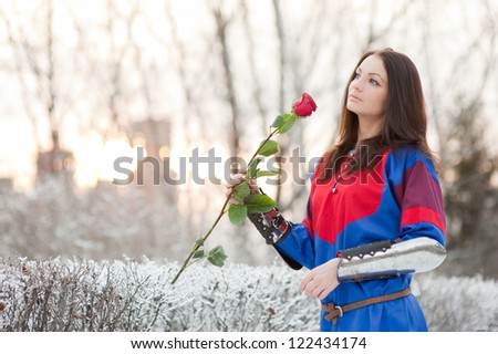 Girl in winter park with live rose