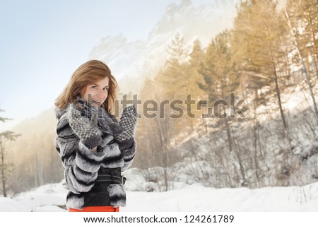 girl in winter clothes on a background of mountains
