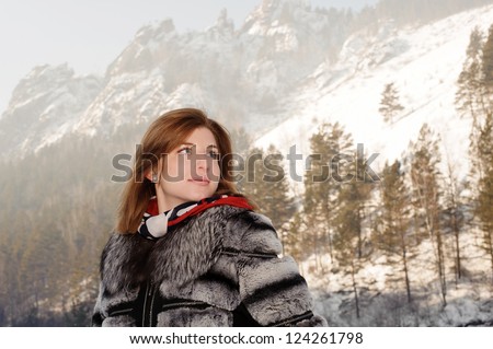 girl in winter clothes on a background of mountains