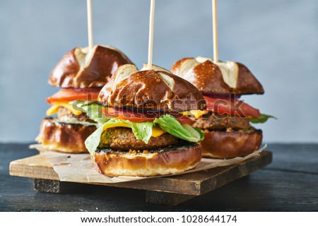 three vegan burger sliders with pretzel buns