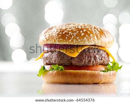 single cheeseburger with silver background and selective focus