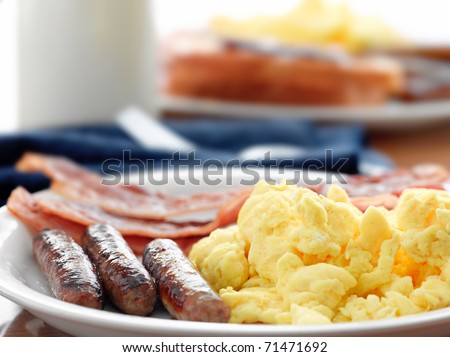 breakfast meal with sausage and scrambled eggs with bacon.