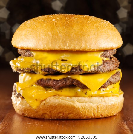 big cheeseburger with melted cheese and glittery background.