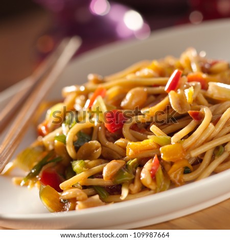 spicy thai noodles with chopsticks shot closeup