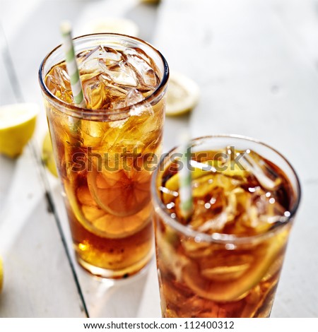 two cold iced tea with straws and lemon slices.