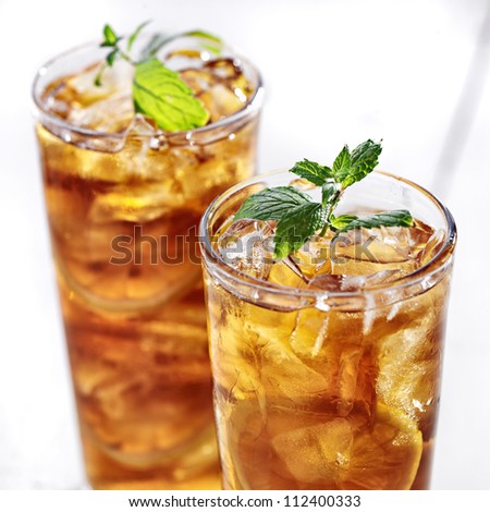 cold iced tea with mint garnish and sliced lemons