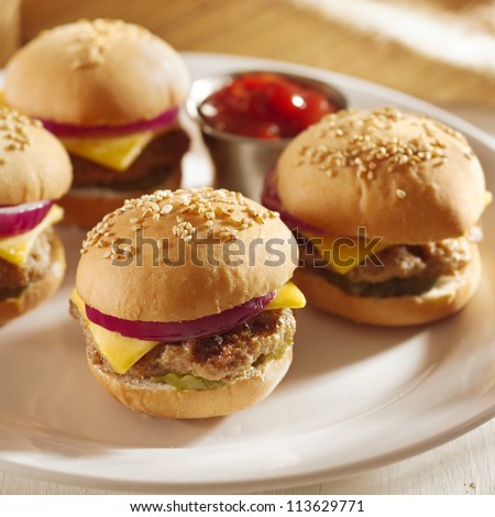 mini burgers with cheese, onion and pickle closeup with ketchup
