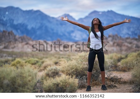 female hiker at alabama hills park with arms out