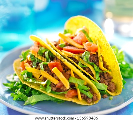 Mexican food - Hard shell tacos with beef, cheese, lettuce and tomatoes
