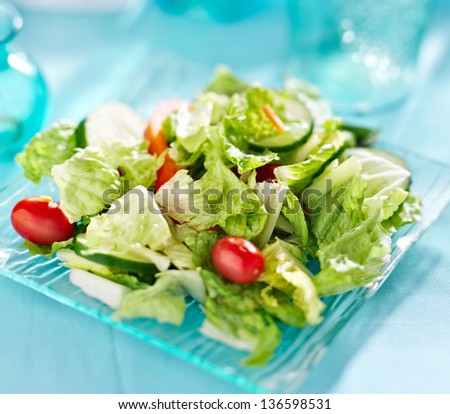 Garden salad with fresh vegetables on glass plate.