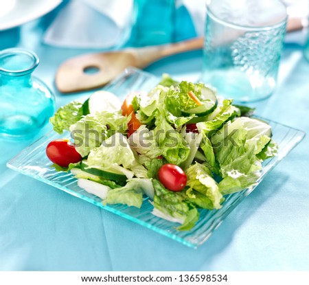 Garden salad with fresh vegetables on glass plate.