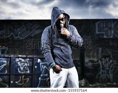 man in hoodie in front of graffiti