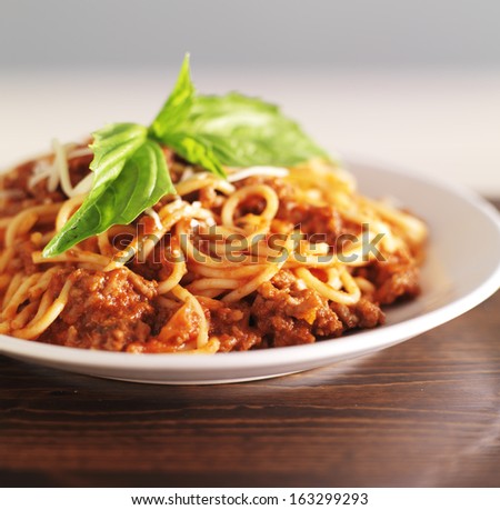 spaghetti bolognese with basil garnish