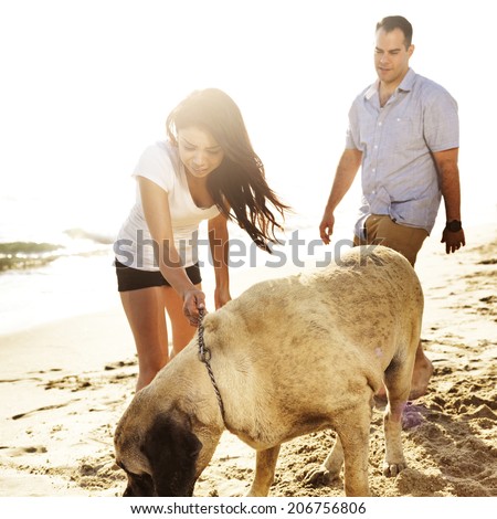 couple playing with pet dog.