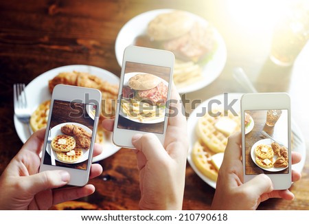 friends using smartphones to take photos of food with instagram style filter