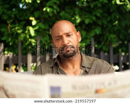mature african american man reading newspaper