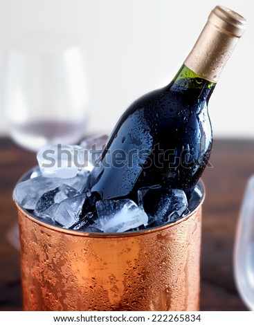 wine bottle in ice bucket with glasses