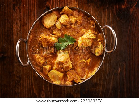 overhead photo of a batli dish with indian butter chicken curry