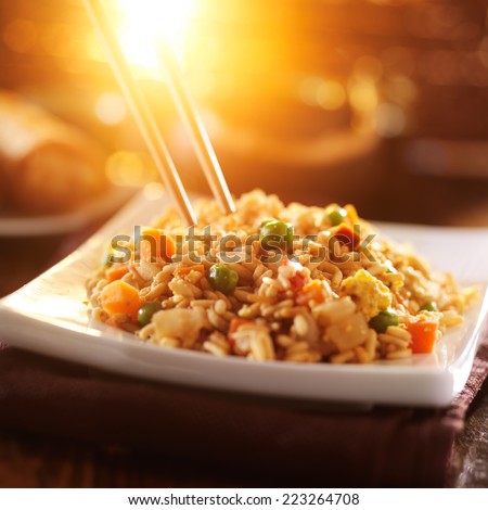 eating chinese vegetable fried rice with chopsticks