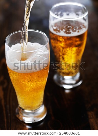 pouring beer into a tall mug on slate table