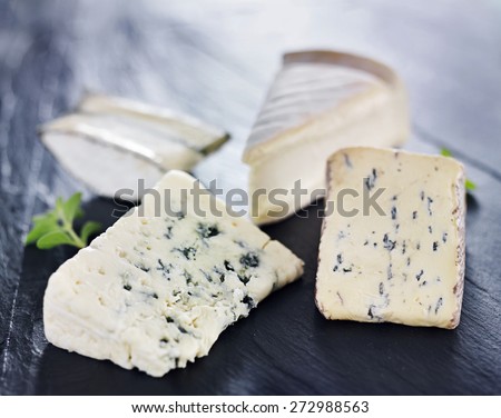 assortment of gourmet artisanal cheeses on slate cheese tray