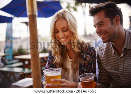 couple drinking beer at outdoor bar shot with selective focus