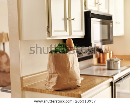 paper grocery bag of freshly bought food from store sitting on kitchen counter