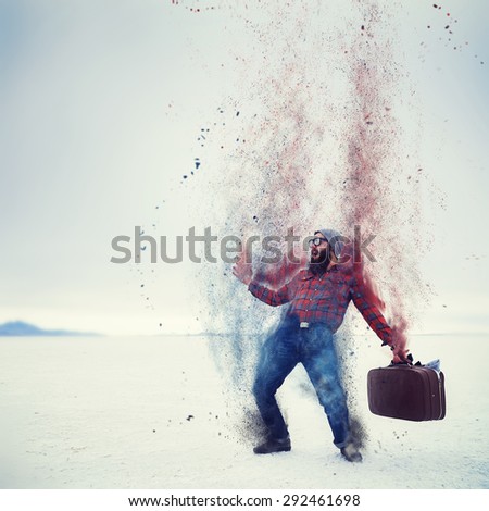 hipster with beard and suitcase turning into dust on the salt flats with retro filter