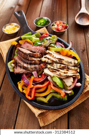 chicken and steak mexican fajitas in iron skillet