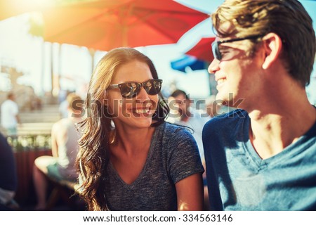 happy dating couple at outdoor restaurant with lens flare and shot with selective focus