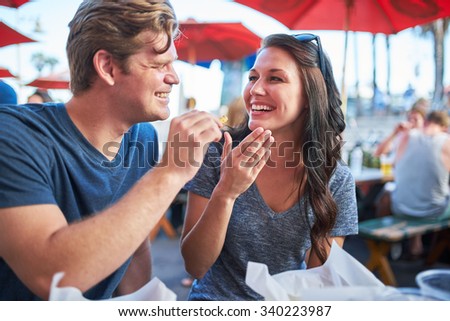 playful couple on date eating french fries shot with selective focus