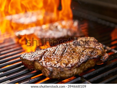 grilling new york strip steaks over flames