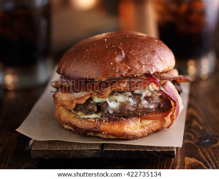 juicy bacon cheeseburger on rustic table