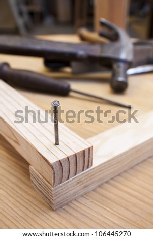 hammer and nail in wood table construction background